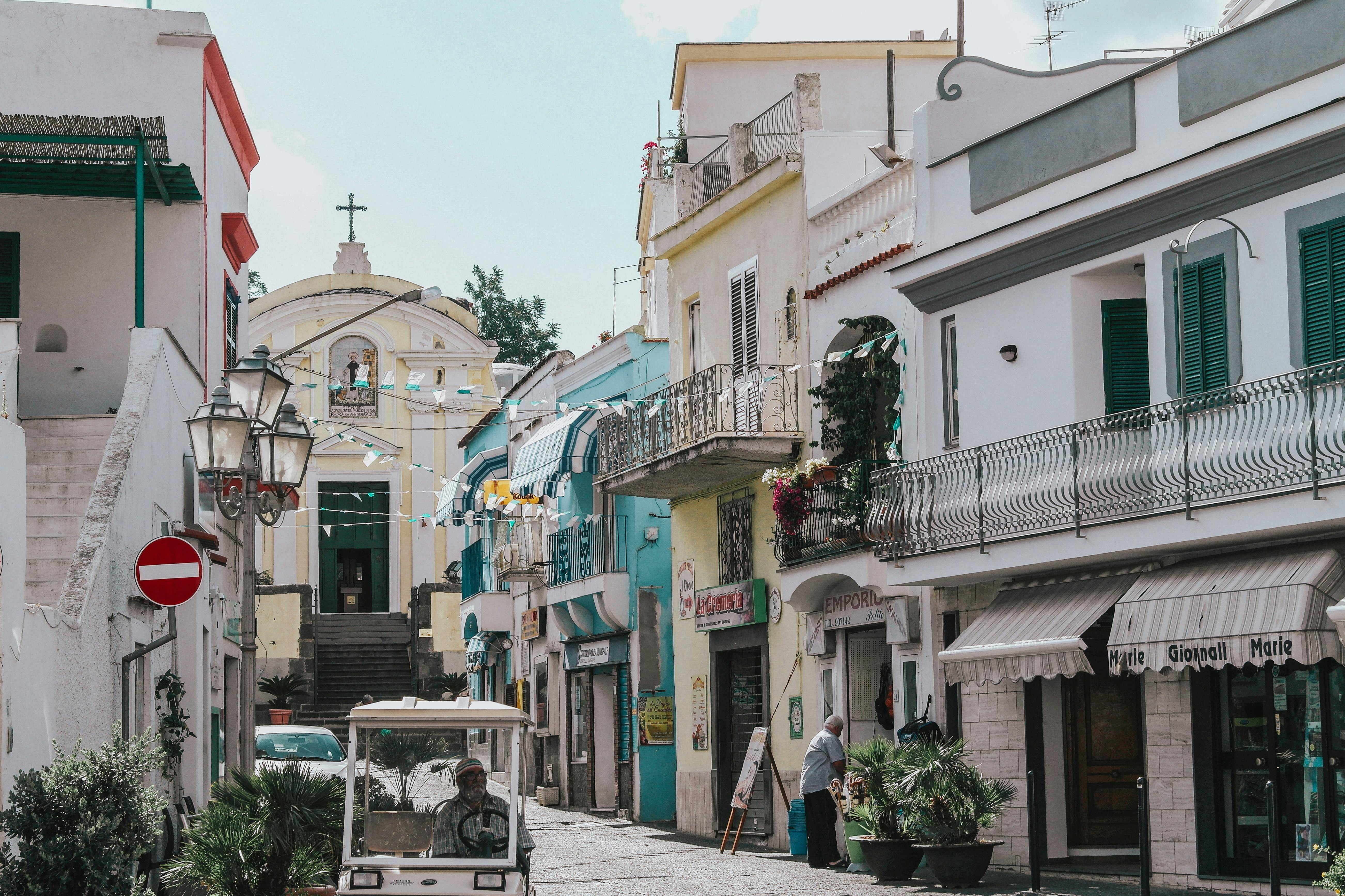 Quaint street view in Ischia, Italy showcasing colorful facades and local life.
