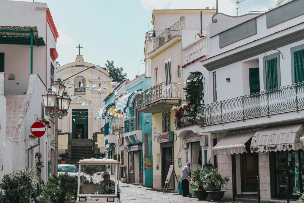Quaint street view in Ischia, Italy showcasing colorful facades and local life.